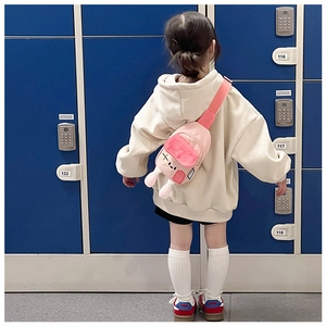 Détail d'un sac bandoulière rose pour enfant avec oreilles de lapin 3D et broderie