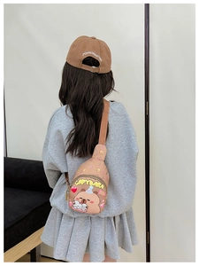 Detail of adjustable strap and cartoon capybara print on a brown children chest bag
