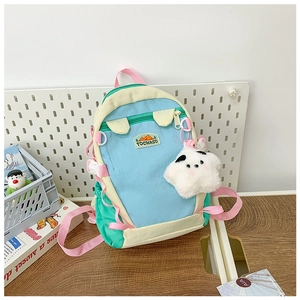 Detail of cute school backpack with pastel colors, mountain logo and cloud pendant