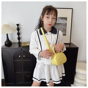 Gros plan d'un sac bandoulière jaune vif avec surpiqûres en cœur pour petite fille