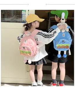 Outdoor shot of two kids wearing cute cartoon hamburger backpacks in pink and blue