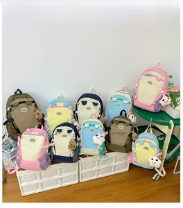 Detail view of multi-color nylon school backpacks with cute charms and ear decorations