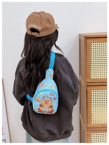 Rear view of a child wearing a blue Kapibara crossbody chest bag with adjustable strap