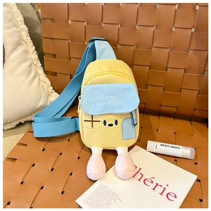 Détail du sac de poitrine enfant en forme de maison avec pieds en peluche sur un fauteuil