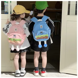 Detail view of pink and blue kids backpack with 3D cartoon burger legs in a lifestyle setting