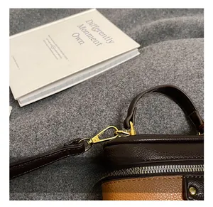 Detailed macro view of litchi leather grain with golden metal hook on child's handbag