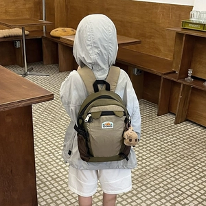 Kids cute cartoon backpack in khaki and green with a plush bear pendant for school