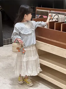 Young girl holding a stylish cream box handbag with litchi texture in a lifestyle setting.