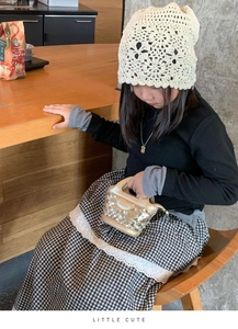 Look mode enfant avec un mini sac à main pailleté doré et un bonnet en crochet chic