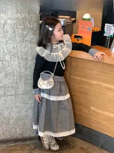 Detail of a sparkling silver sequin crossbody bag for kids paired with a chic outfit