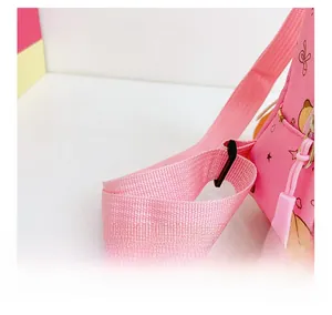 Detail showing the adjustable wide shoulder strap and pink fabric of the cute cartoon bag