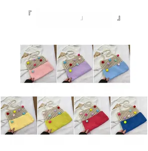 Close-up of colorful pom-pom details and handmade crochet knit textures on crossbody bag