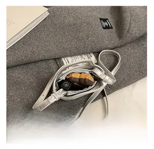 Mini sac bandoulière argenté à paillettes montrant l'espace intérieur du sac