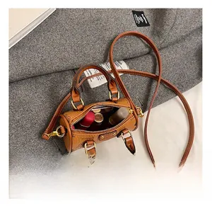 Internal view of a mini brown cylinder bag showing capacity for lipsticks and small items