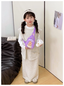 Purple Capybara kids crossbody bag shown on a young girl in a warm indoor home setting