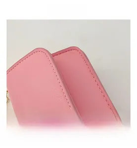 Detailed macro view of pink leather kids crossbody bag showing fine stitching and grain texture