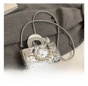 Close-up of silver sequin mini bag featuring a pearl handle and slim metal shoulder strap