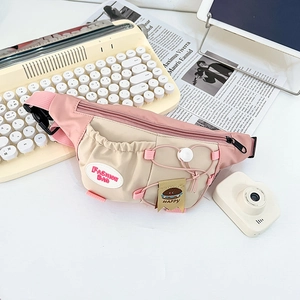 Detail of pink and beige kids chest bag featuring cartoon tags on a lifestyle background