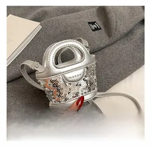 Vue macro du mini sac à main à paillettes argentées avec lettrage embossé et détails