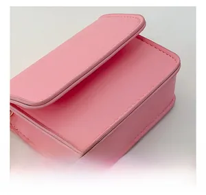 Close-up of pink faux leather mini bag featuring precise stitching and flap detail