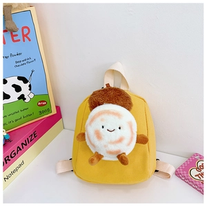 Detail of cute plush cartoon character on a mini yellow canvas backpack for kids