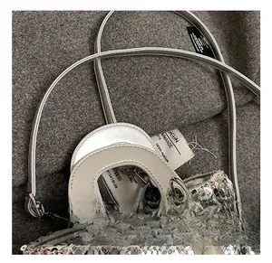 Detail of silver sequin toddler handbag with faux pearl pendant and stylish leather handle
