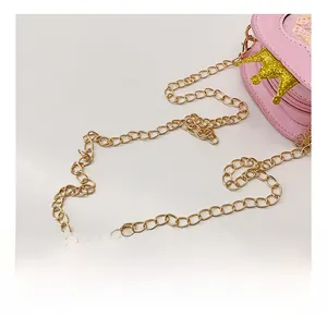 Detail der goldenen Metallkette an einer rosa herzförmigen Prinzessin-Tasche