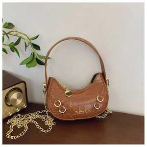 Dettaglio mini borsa marrone trama coccodrillo con catena dorata e manico in metallo