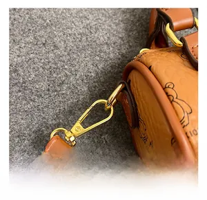 Detailed close-up of the premium golden metal lobster clasp and bear print leather strap