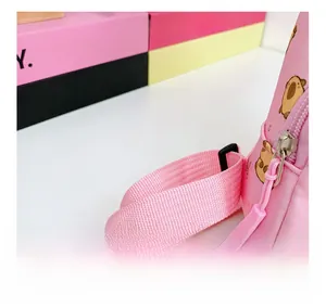 Detail view of pink adjustable woven strap on children's backpack with capybara print
