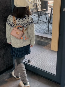 Pink mini cylinder box bag for girls shown on model in modern casual street setting