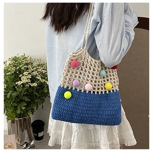 Detail of crochet shoulder bag with colorful pom-poms and blue contrast knit