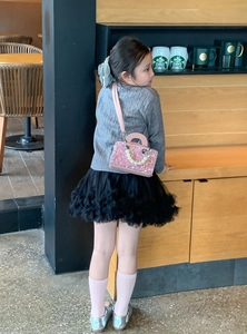 Detailed shot of pink sequin girl's crossbody bag with pearl handle and leather strap