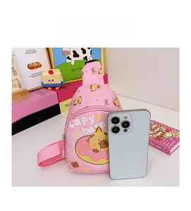 Detailed view of pink Capybara kids crossbody bag next to a phone for size reference