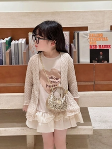 Detail of a sparkling gold sequin crossbody bag styled with a girls' fashion outfit