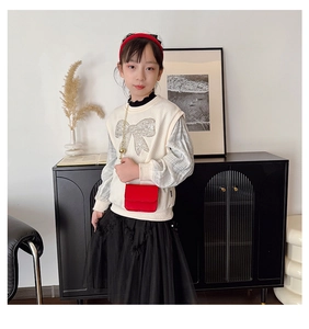 Detail view of a mini red square crossbody bag with a chain strap for kids fashion