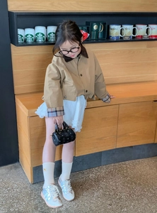 Kids' fashion outfit styling featuring a mini black cylinder handbag and khaki jacket