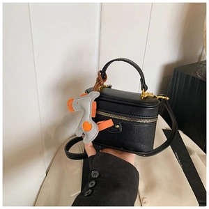 Detail of black litchi grain mini box bag with metallic zipper and horse charm