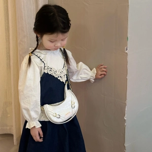 Bambina che indossa borsa a tracolla bianca a mezzaluna con trama coccodrillo e catena