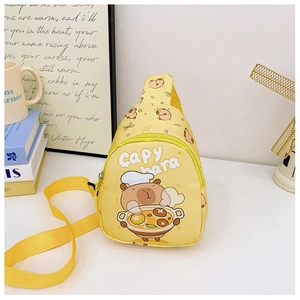 Detail of yellow Capybara sling bag with cartoon print and metal zipper on white table