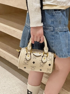 Detailed view of child holding a cream mini Boston bag with bear prints and gold hardware