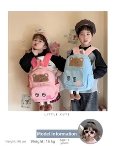 Detailed view of cute bear backpacks in pink and blue on kids with size info