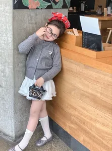 Fillette en cardigan gris avec patch cœur et sac à main élégant à paillettes argentées
