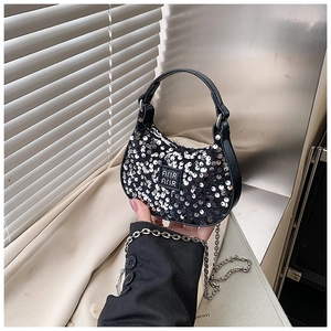 Detail of a mini crescent bag with black sequins, silver chain strap, and logo plate
