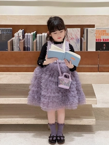 Détail d'un sac à main violet à paillettes avec une robe de fête en tulle multicouche