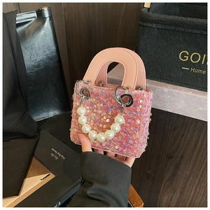 Detailed view of pink sequin girls handbag with elegant pearl handle and silver rings