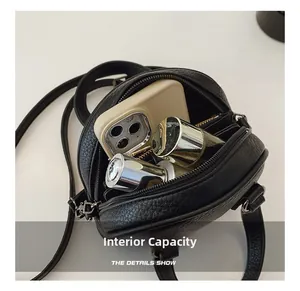 Internal capacity of the mini round shell bag showing space for phone and makeup