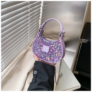 Detailed macro view of purple sequins and chain strap on a mini girl's crescent handbag
