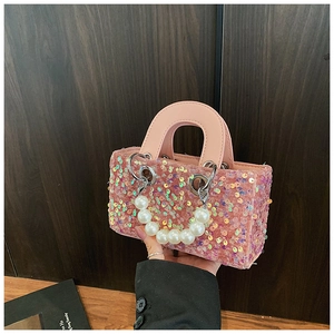 Detail of pink sequin girl handbag with pearl handle and metallic ring accents