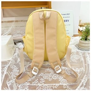 Detail view of yellow toddler backpack featuring wide ergonomic straps and side mesh pocket